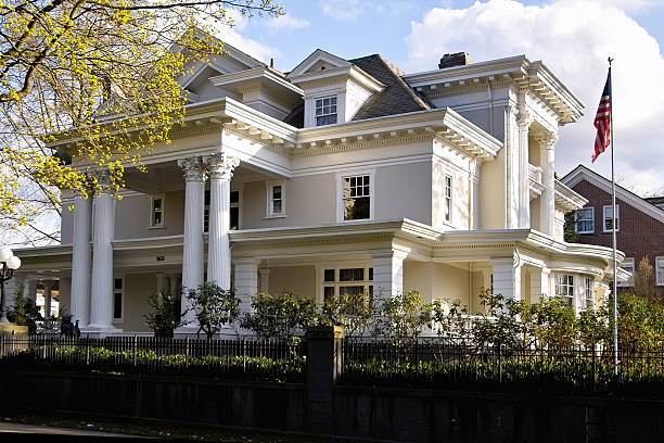 Large white home with American flag in yard.