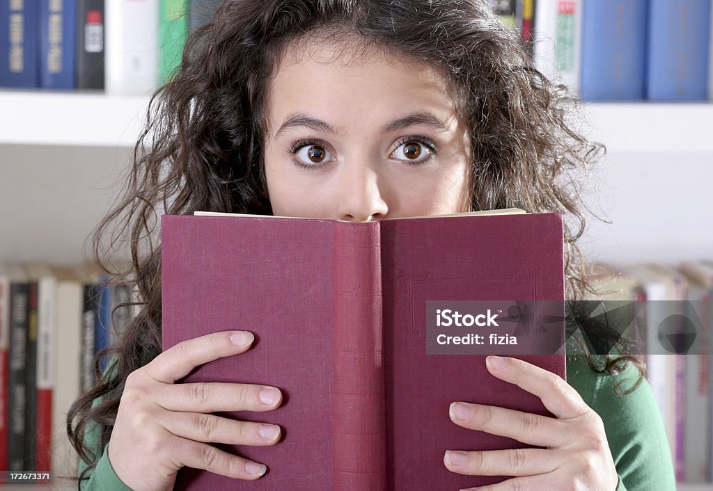 suprised 여자아이 숨겨져 미진 책 - 로열티 프리 놀라움 스톡 사진