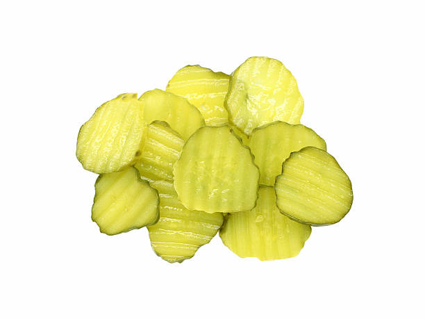 pickle slices A pile of sliced dill pickles. Isolated on white. pickled stock pictures, royalty-free photos & images