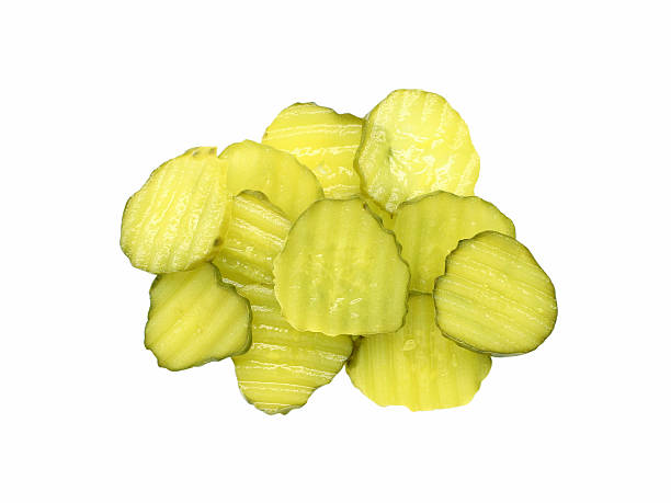 pickle slices A pile of sliced dill pickles. Isolated on white. dill pickle stock pictures, royalty-free photos & images