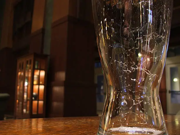 "An empty beer glass sitting on a table in a bar. It's almost sad. Useful for illustrating responsible drinking, or the importance of finishing the glass.See other"