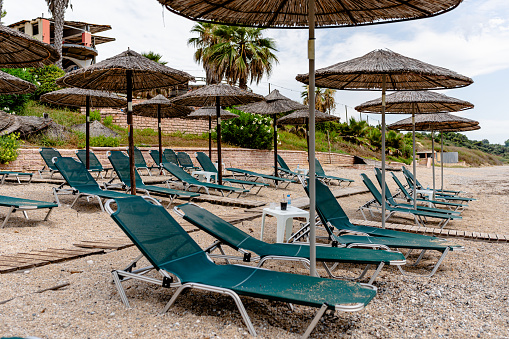 Strategically placed chairs and umbrellas await, setting the scene for hours of relaxation and serene beachfront views