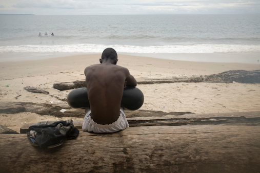 Young African wait in the beach