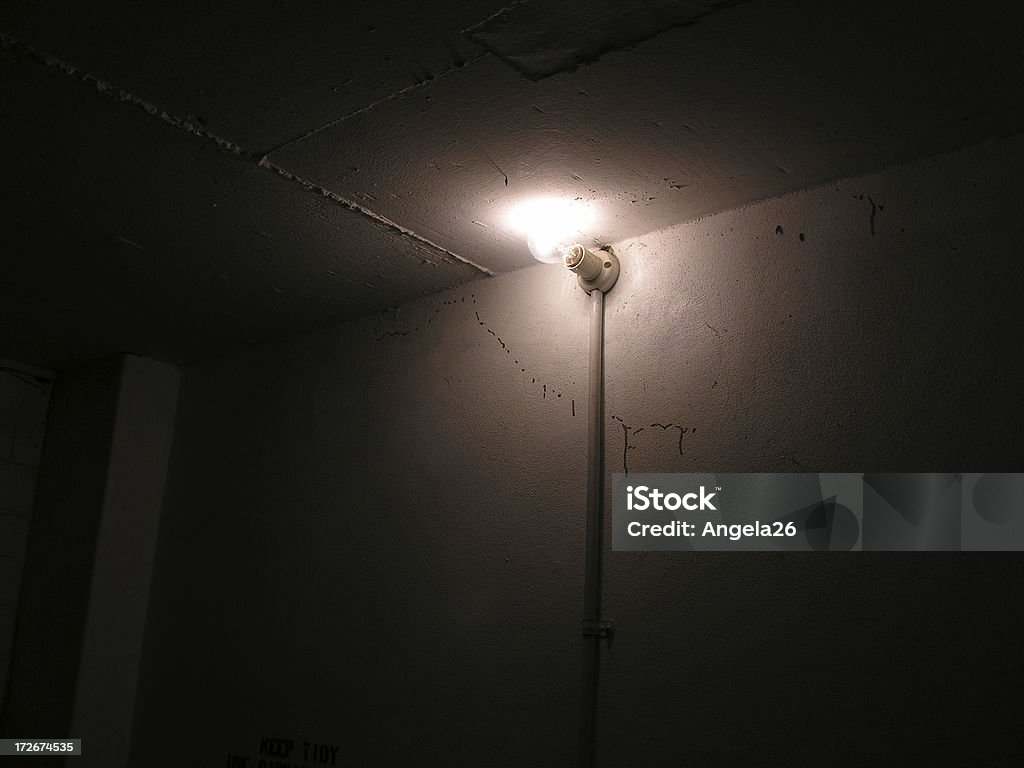 Light bulb in dingy room A naked lightbulb in a storage room. Light Fixture Stock Photo