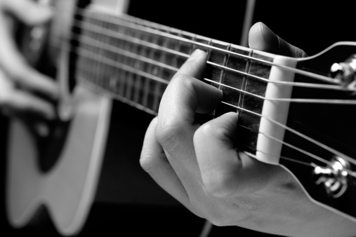 A guitarist plays an acoustic guitar.