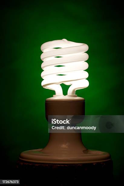 Compact Fluorescent Lighbulb Against Green Background Stock Photo - Download Image Now