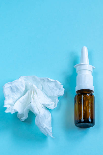 istock Nasal spray and crumpled paper tissues on blue background. 1726765029