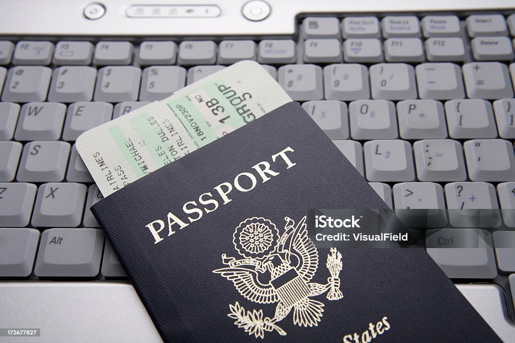 Documenti di viaggio sulla tastiera del computer portatile - Foto stock royalty-free di Passaporto