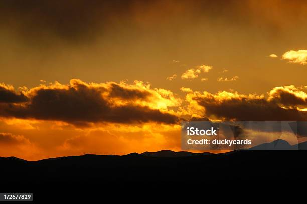 Ardientes Puesta De Sol Sobre Las Montañas Foto de stock y más banco de imágenes de Amarillo - Color - Amarillo - Color, Anochecer, Belleza de la naturaleza