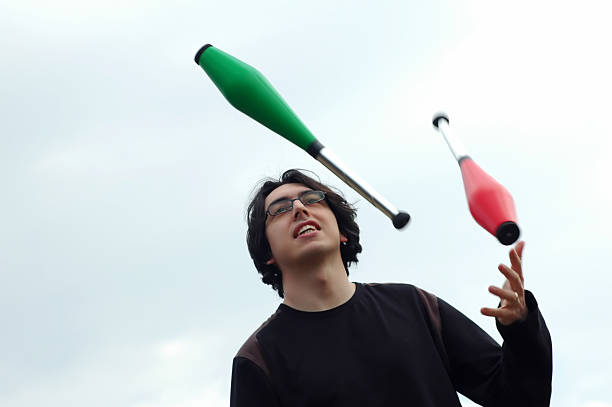 guy with colorful juggling clubs against the sky