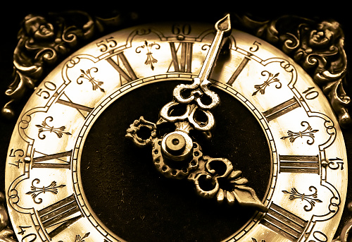 Old beautiful pocket watch lying in the beach sand.