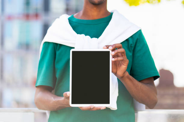 istock Young guy in casual clothes holding digital tablet with blank screen, place for ads mockup outdoors 1726800613