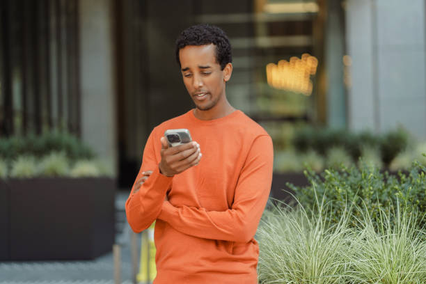 istock Smiling African American man holding mobile phone reading text message 1726801201