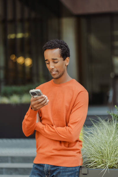 istock Smiling African American man holding mobile phone reading text message 1726801204