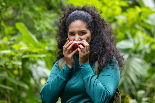 Happy young woman tasting dragon fruit