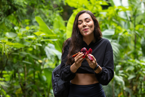 Young woman tasting red prickly pear