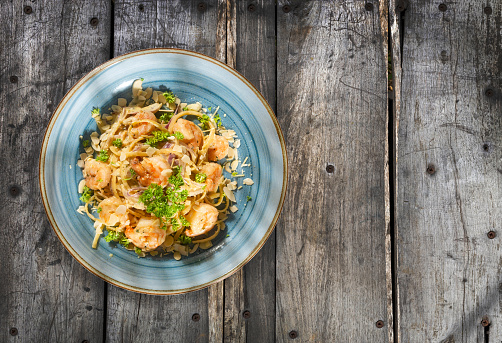 Fettuccine with shrimp and parsley - Rustic wooden background