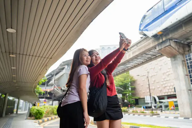 Young women using smartphone at bus stop