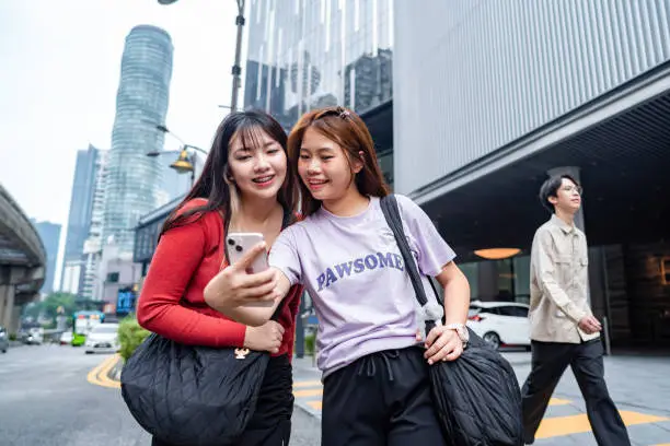 Young asian female travellers using smartphone in the city