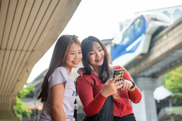 Young women using smartphone at bus stop