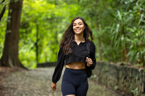 Portrait of a woman walking smiling among trees and fresh air.