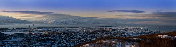 A panorama shot of a small norwegian town by the ocean.