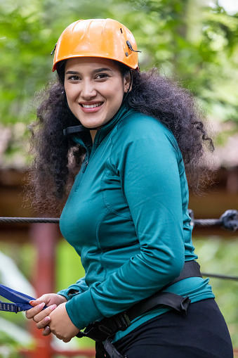 portrait of young woman wearing safety helmet to climb the zip line