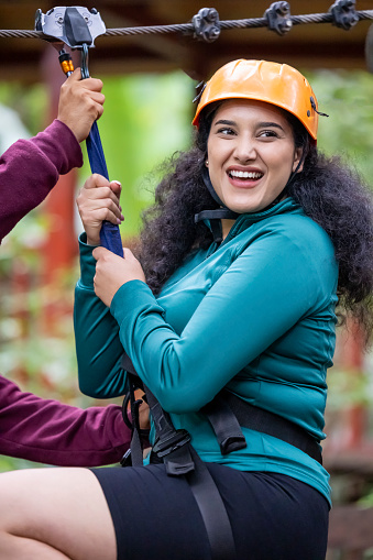 portrait of happy young woman wearing safety helmet to climb the zip line
