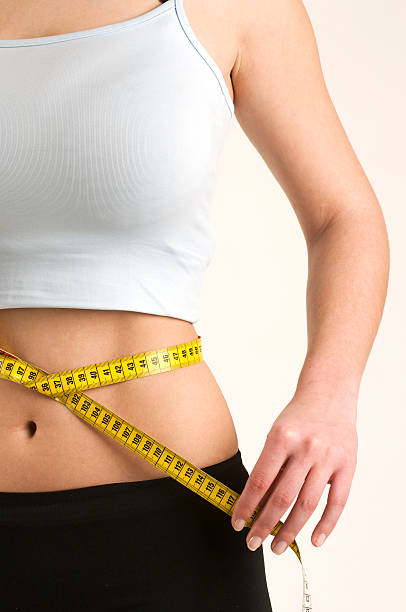 Woman measuring her waist stock photo