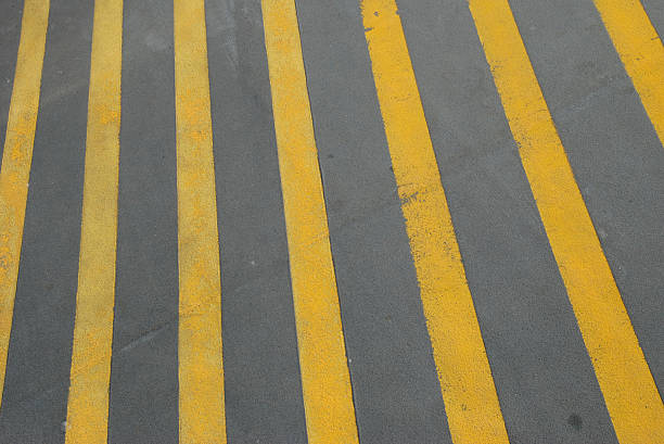 strada gialla a righe grigio sfondo all'aperto - dividing line single line striped in a row foto e immagini stock