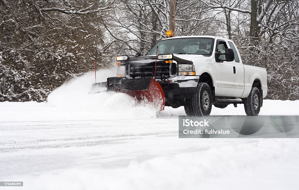 Plowing the Road Man in pickup truck plowing road during snow storm Snow Stock Photo