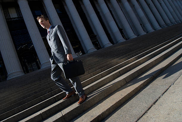 istock Businessman Lawyer in Suit Standing Outdoors on Dark Courthouse Staircase 172685985