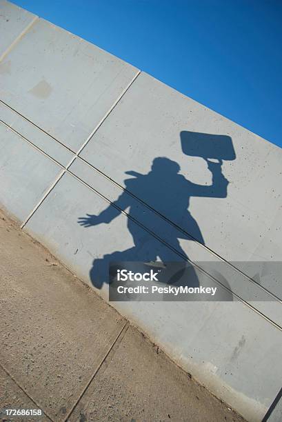 Sombra De Un Empresario Jumps Contra La Pared De Cemento Foto de stock y más banco de imágenes de Acera