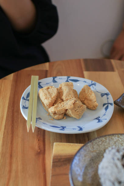 warabi mochi sojabohnenpulver (kinako) und brauner zuckersirup. japanisches dessert. pudding aus adlerfarn-stärkeknödel. - bracken starch dumpling stock-fotos und bilder