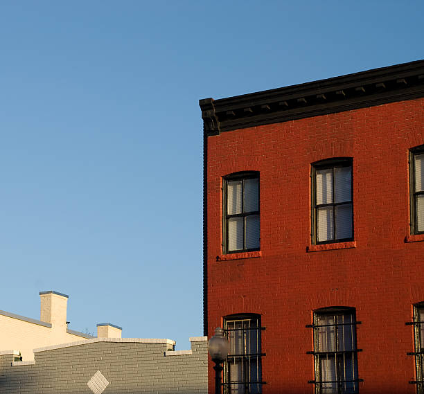 istock Brick Wall painte red against a blue sky 172686500