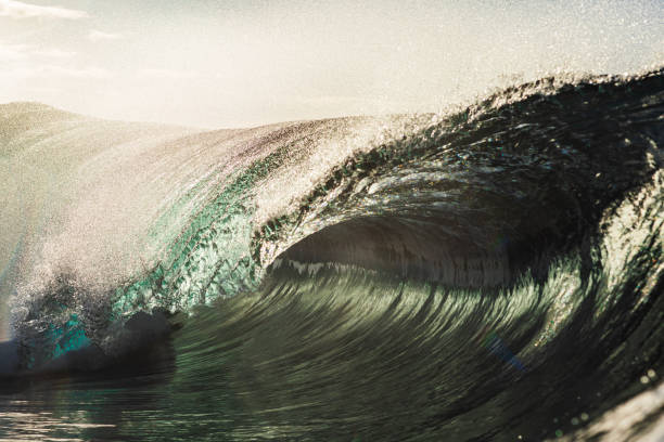 istock Backlit ocean wave breaking in bright golden morning light 1726865413