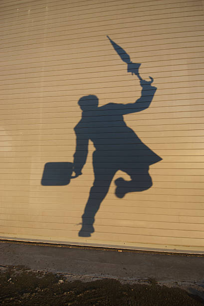 shadow geschäftsmann springt in eine pfütze - rush hour commuter shadow focus on shadow stock-fotos und bilder