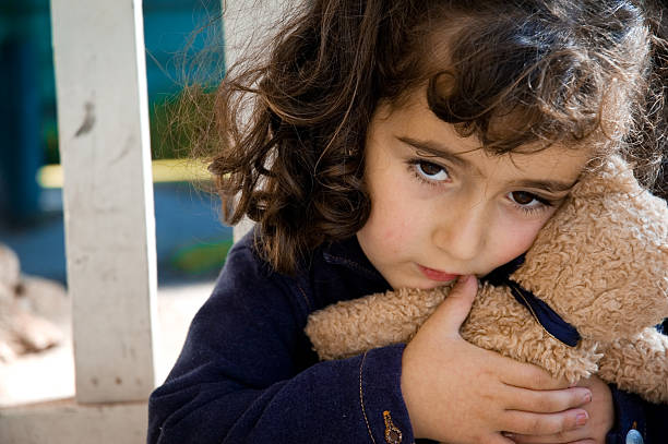 Spaventata/triste bambina con giocattolo - foto stock