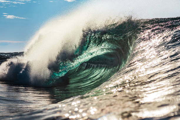 istock Large teal ocean wave breaking in bright morning light 1726869628