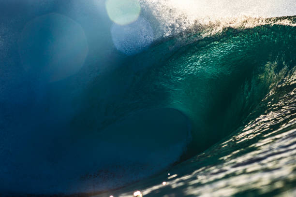 Powerful large aqua marine ocean wave breaking in bright morning light. Photographed at sunrise while swimming in the sea off the south coast of NSW, Australia.