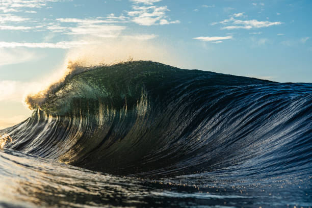 istock Backlit ocean wave breaking in bright golden morning light 1726876511