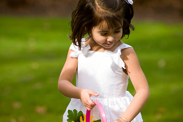 Beautiful little girl dressed up for Easter on egg hunt outdoors. Copy space to left. CLICK FOR SIMILAR IMAGES AND LIGHTBOX WITH EASTER/SPRING IMAGES OR MORE CHILDREN.