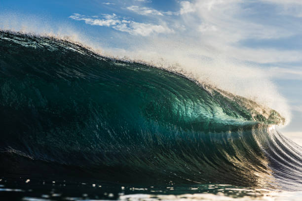 istock Backlit ocean wave breaking in bright golden morning light 1726879179