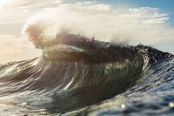 istock Backlit ocean wave breaking in bright golden morning light 1726881242