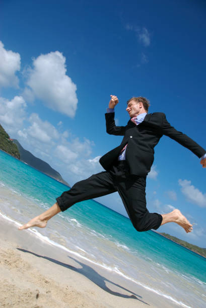 istock Businessman in Dark Suit Leaps on Beach 172688268