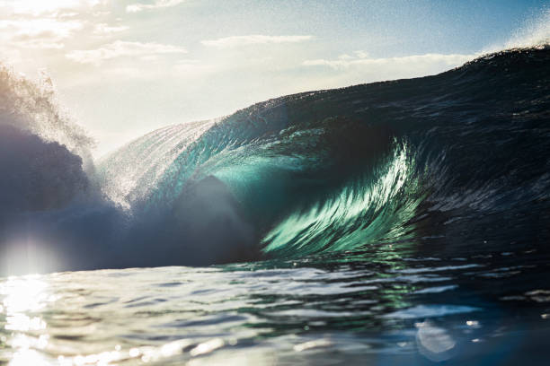 istock Backlit ocean wave breaking in bright golden morning light 1726882814