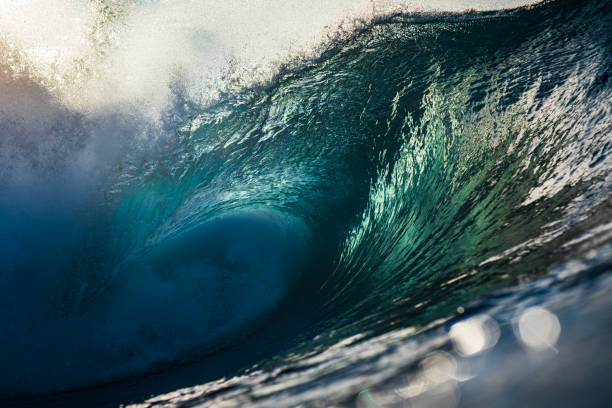 istock Backlit ocean wave breaking in bright golden morning light 1726882825