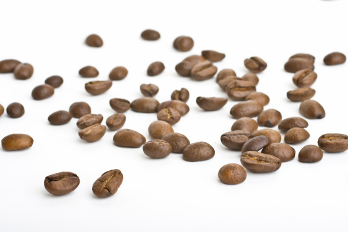 A handful of roasted coffee beans isolated on white