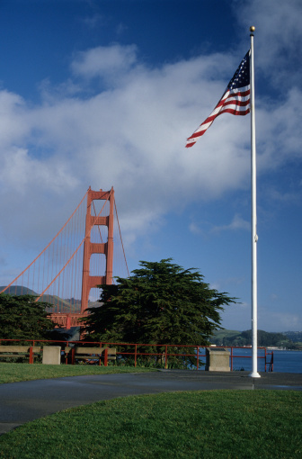 The American Flag flies next to the Golden Gate Bridge