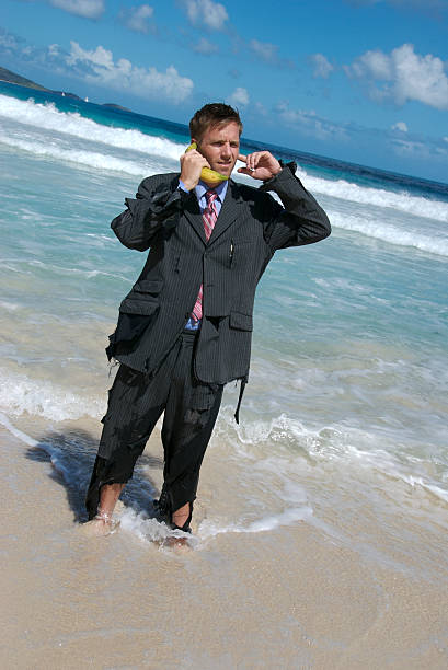 náufrago de negócios fala no telefone de banana - stranded beached beach businessman imagens e fotografias de stock